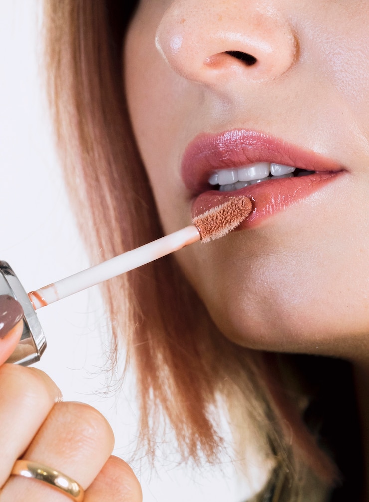 Foto gratuito donna irriconoscibile che applica rossetto