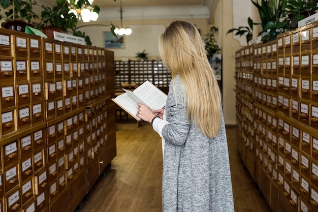 Donna irriconoscibile che legge nella biblioteca