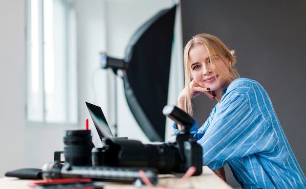 Donna laterale del fotografo che esamina le sue macchine fotografiche