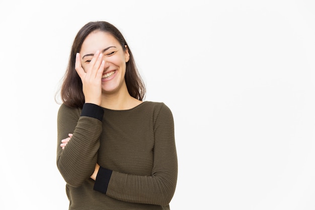 Donna latina gioiosa felice toccando il viso e ridendo