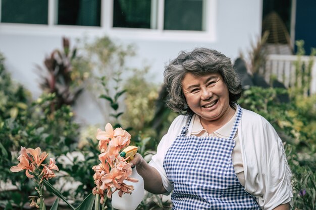 Donna maggiore che raccoglie i fiori in giardino