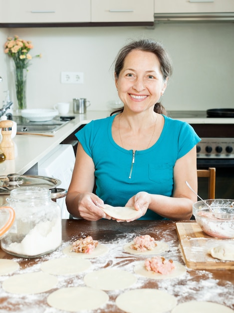 Donna matura che produce gnocchi di carne