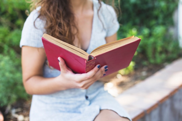 Donna moderna che legge un libro nel parco