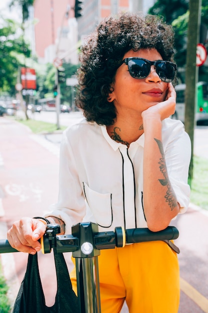Donna moderna in una città con uno scooter elettrico