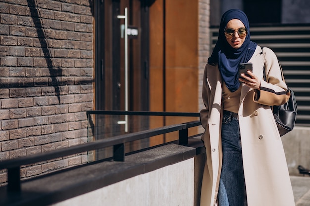 Donna musulmana moderna che parla al telefono