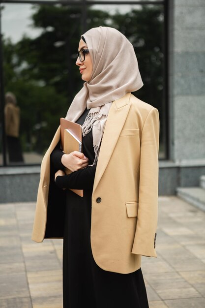 Donna musulmana moderna ed elegante in hijab in una strada di città