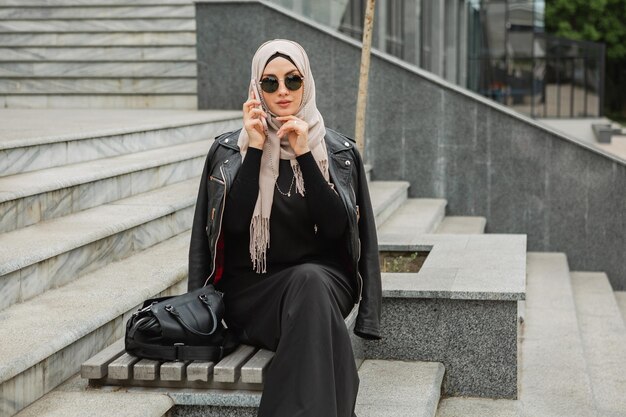 Donna musulmana moderna ed elegante in hijab in una strada di città