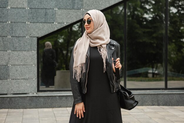 Donna musulmana moderna ed elegante in hijab in una strada di città