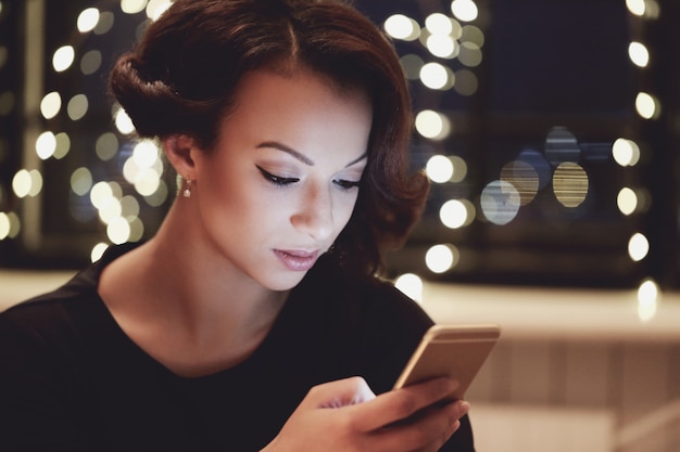 Donna nel ristorante utilizzando lo smartphone