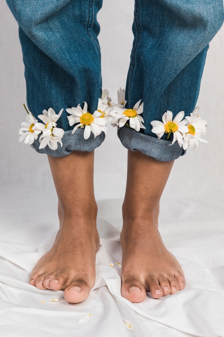 Foto gratuito donna nera con fiori margherita in polsini jeans