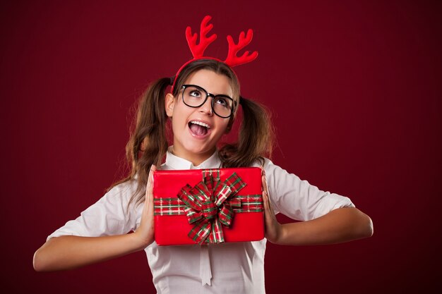 Donna nerd che tiene regalo di Natale rosso