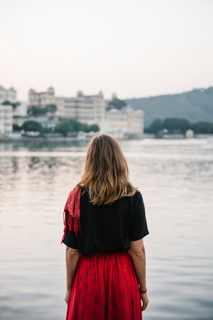 Foto gratuito donna occidentale che gode di una vista del lago taj in udaipur