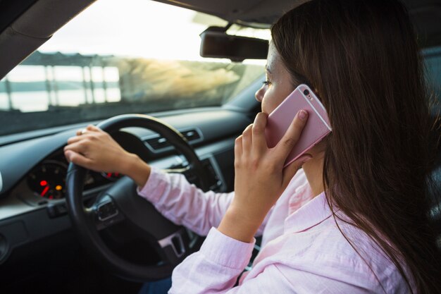 Donna parlando sul cellulare, guidando l&#39;auto