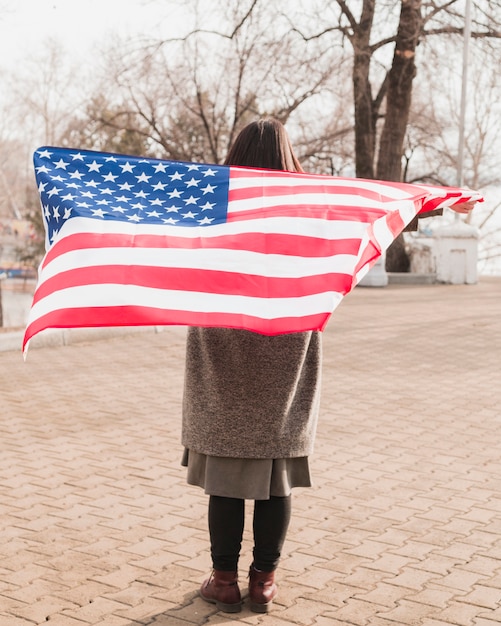 Donna patriottica con bandiera americana al parco