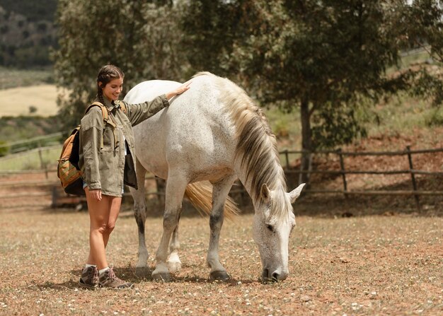 Donna piena del colpo che accarezza il cavallo