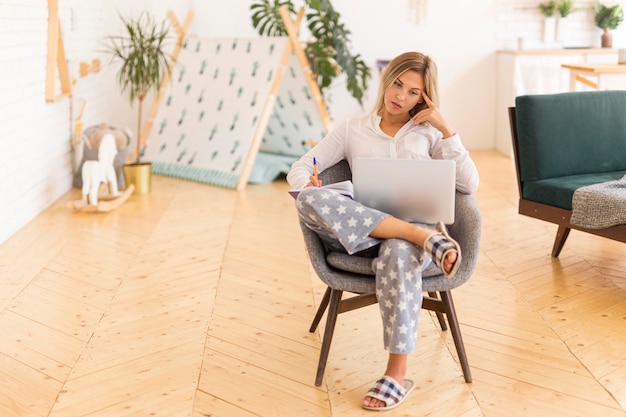 Donna piena del colpo che esamina computer portatile