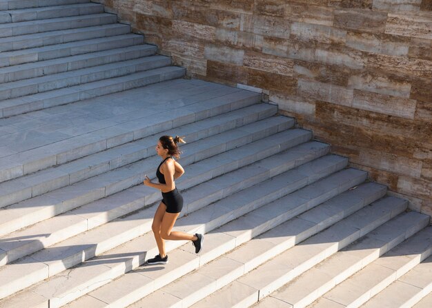 Donna piena del colpo che funziona sulle scale