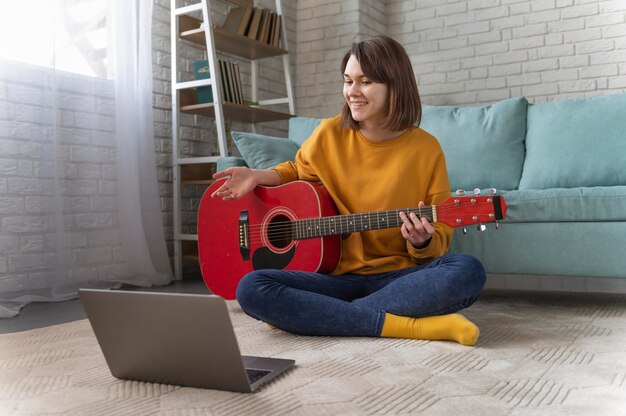 Donna piena del colpo che gioca chitarra