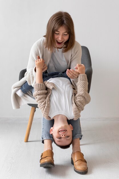 Donna piena del colpo che gioca con il bambino