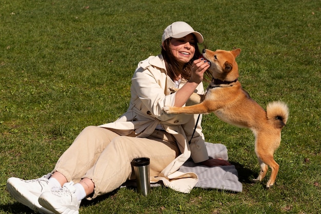 Donna piena del colpo che gioca con il cane sveglio