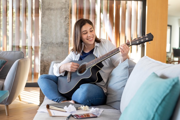 Donna piena del colpo che gioca la chitarra