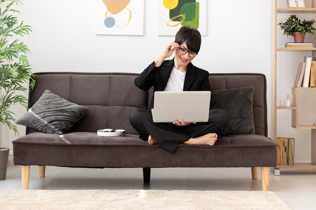 Donna piena del colpo che lavora con il computer portatile