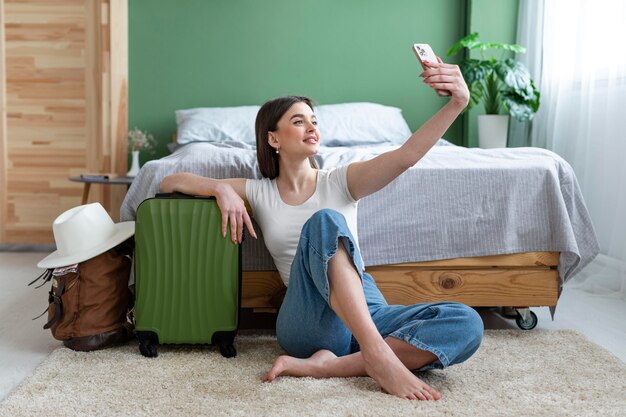 Donna piena del colpo che prende selfie a casa