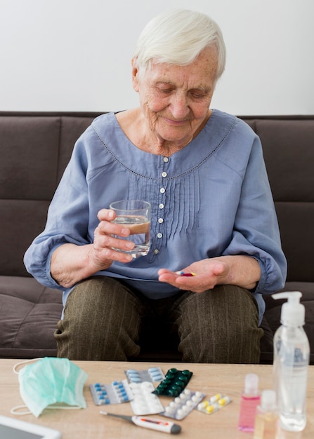 Donna più anziana che prende le sue pillole quotidiane