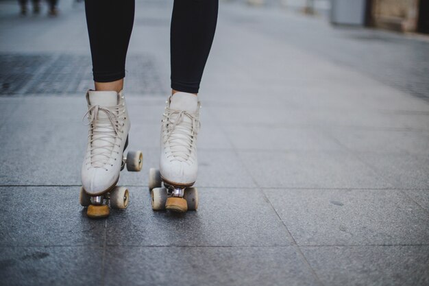 Donna, portante, rollerskates, standing, pavimentazione