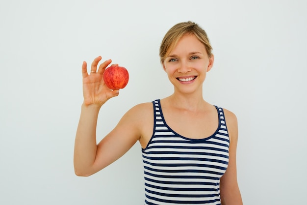 Donna positiva con denti sani che mostrano mela