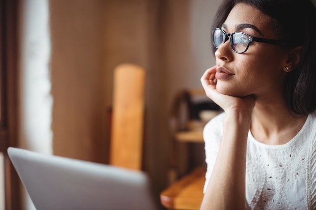 Donna premurosa che si siede con con il computer portatile