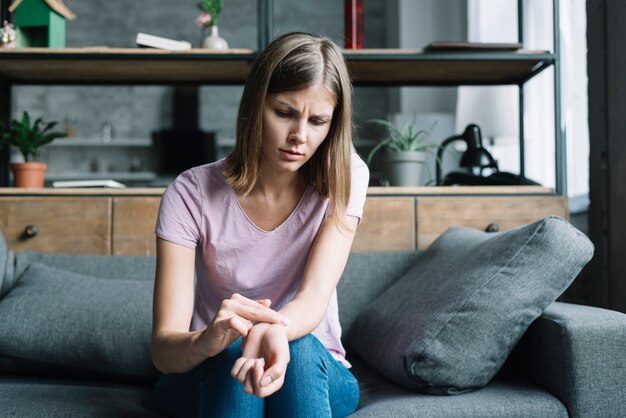 Donna preoccupata che controlla il suo impulso a casa