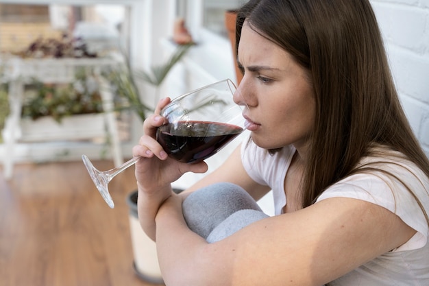 Donna preoccupata di vista laterale che beve vino