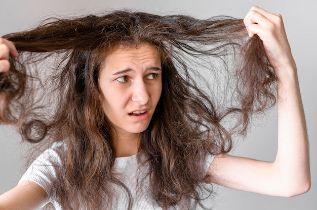 Donna preoccupata per i capelli aggrovigliati