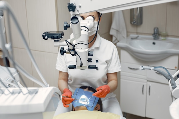 Donna presso l'ufficio del dentista. Il medico conduce un esame. La ragazza tratta i suoi denti