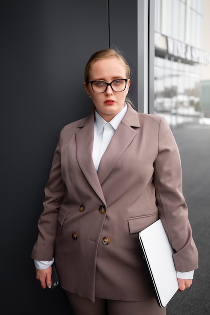 Donna professionale in abito elegante in ufficio con il computer portatile