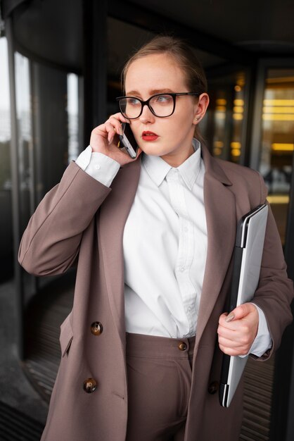 Donna professionale in abito elegante in ufficio con il computer portatile