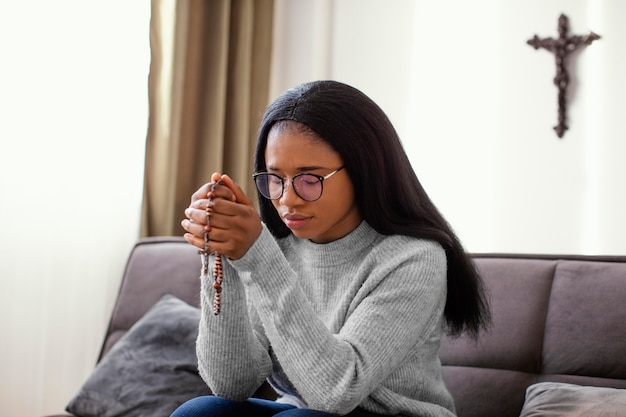 Donna religiosa che tiene i grani del rosario