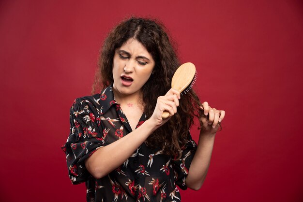 Donna riccia che pettina i suoi capelli.