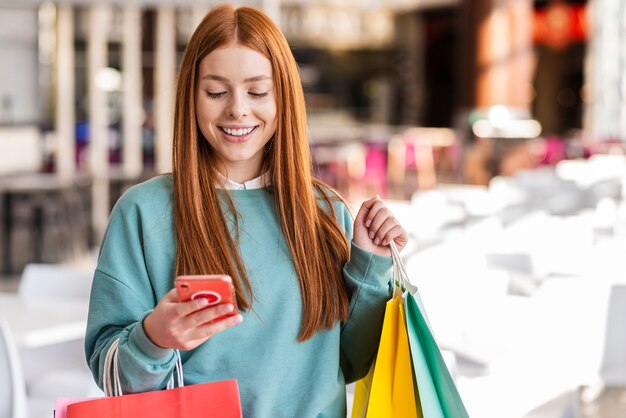 Donna rossa che controlla il suo telefono