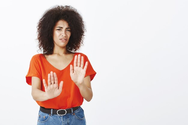 donna scomoda con acconciatura afro in posa in studio