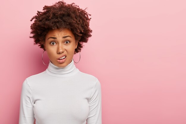 Donna scontenta con taglio di capelli afro, faccia sorride