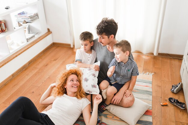 Donna sdraiata sulle ginocchia di suo marito con due bambini