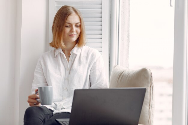 donna seduta a casa e utilizzando un computer portatile