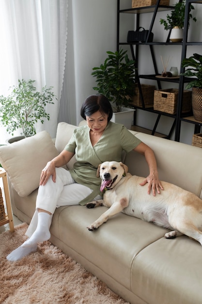 Donna seduta a casa sul divano con il suo cane