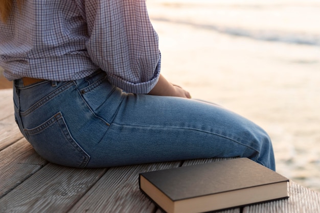 Donna seduta accanto a un primo piano del libro chiuso