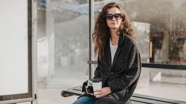 Donna seduta e in attesa nella stazione degli autobus