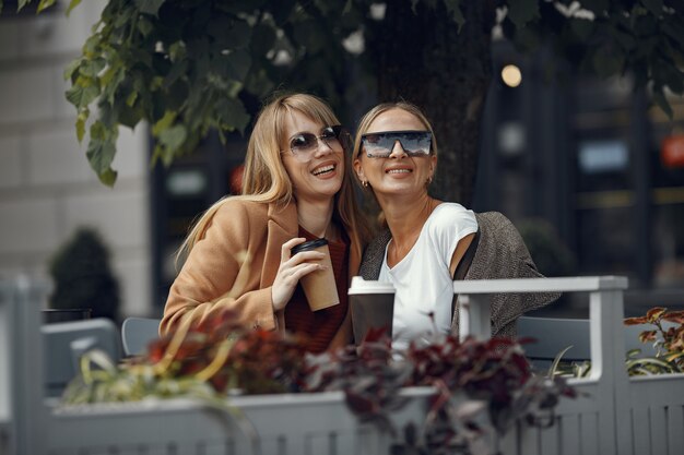 Donna seduta in una città estiva e bere caffè