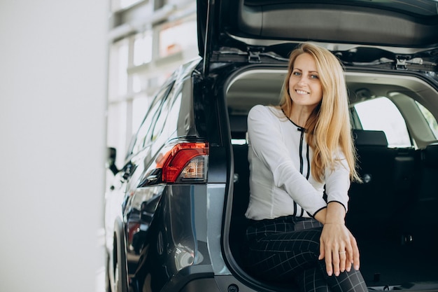 Donna seduta nel bagagliaio della sua auto