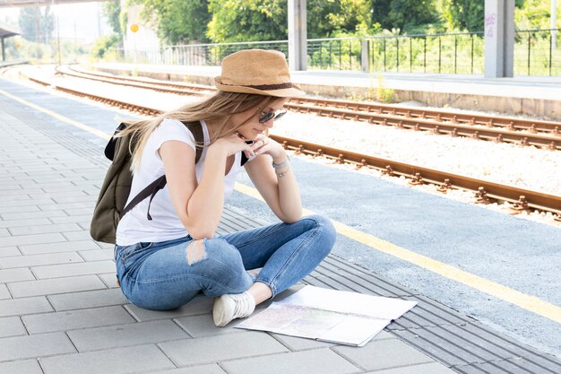 Donna seduta su un piano e guardando una mappa